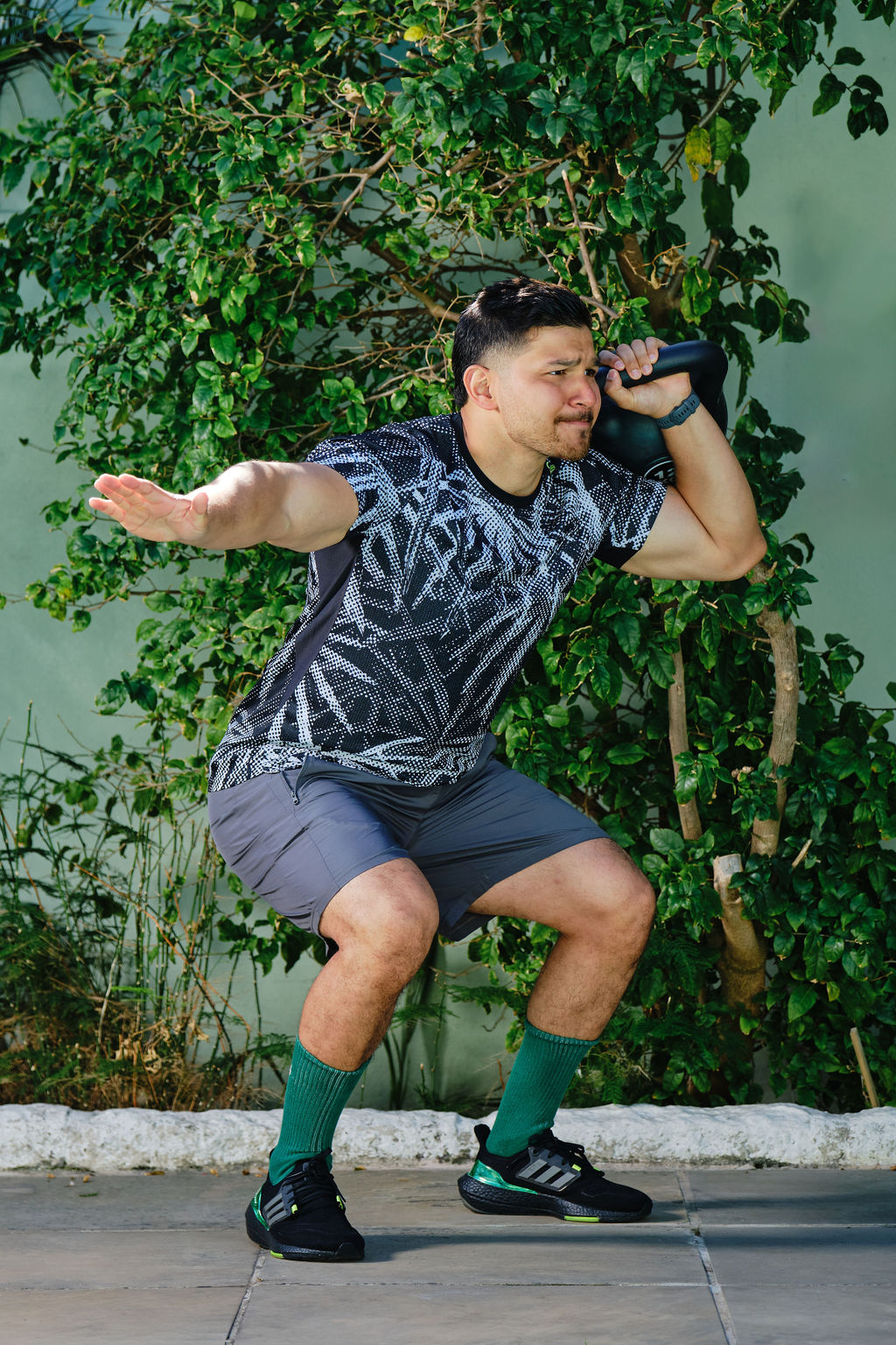 personal trainer squatting with a kettlebell