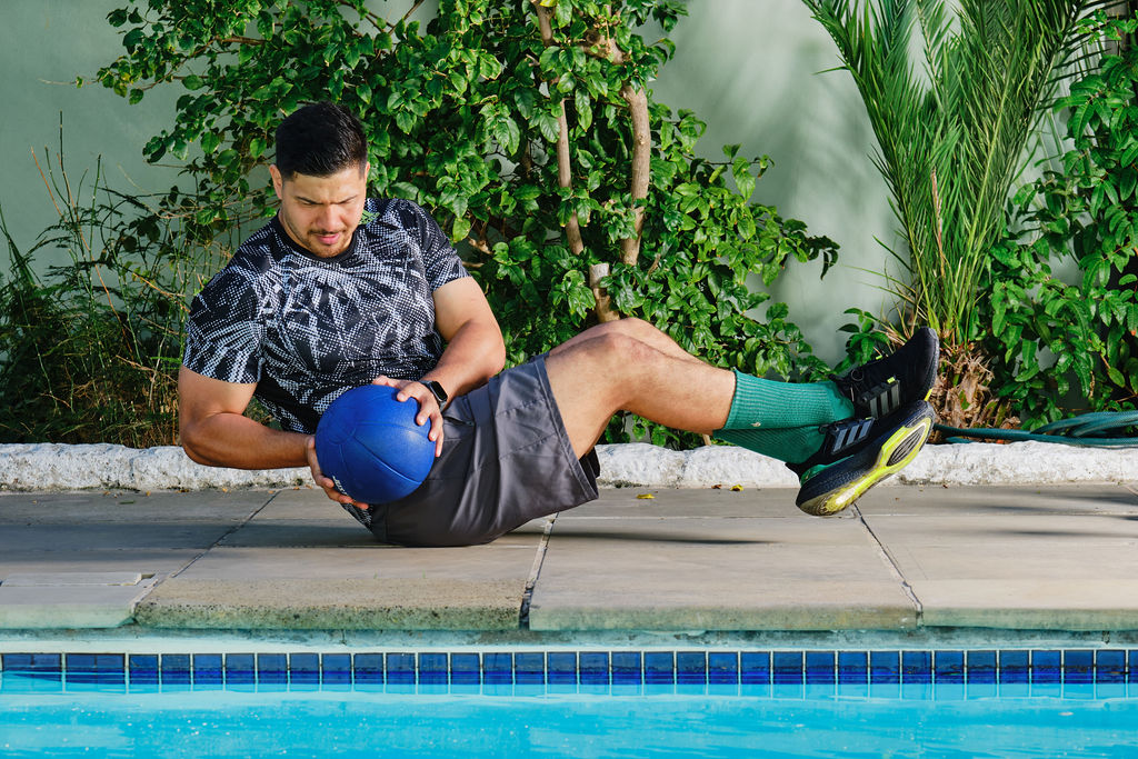 personal trainer doing side swipes with raised legs