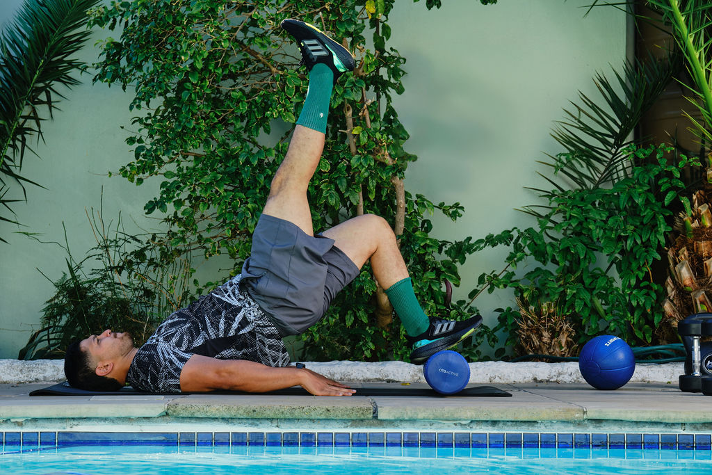 personal trainer laying on the floor lifting one leg
